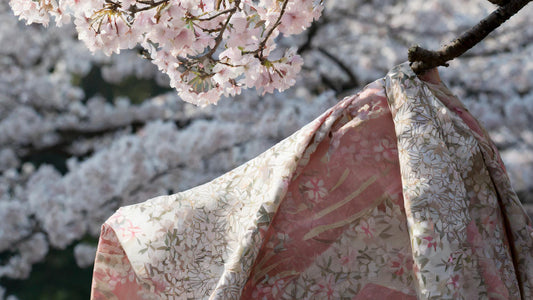 tissu japonais sur une branche et des fleurs de cerisiers au fond